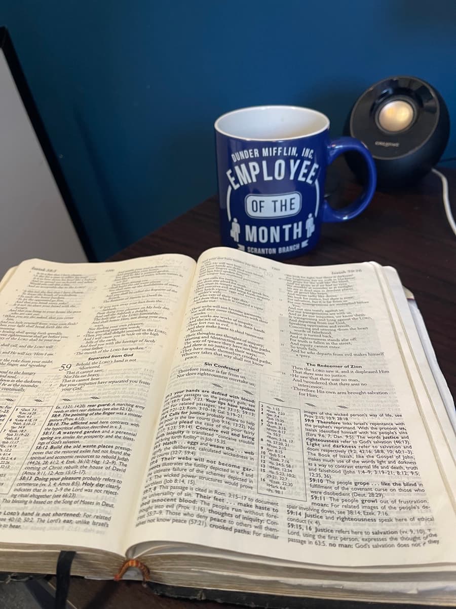 Open Bible on a wooden table with study notes