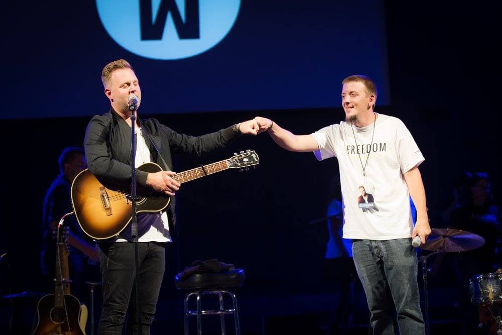 Justin and Matthew West fist-bumping on stage