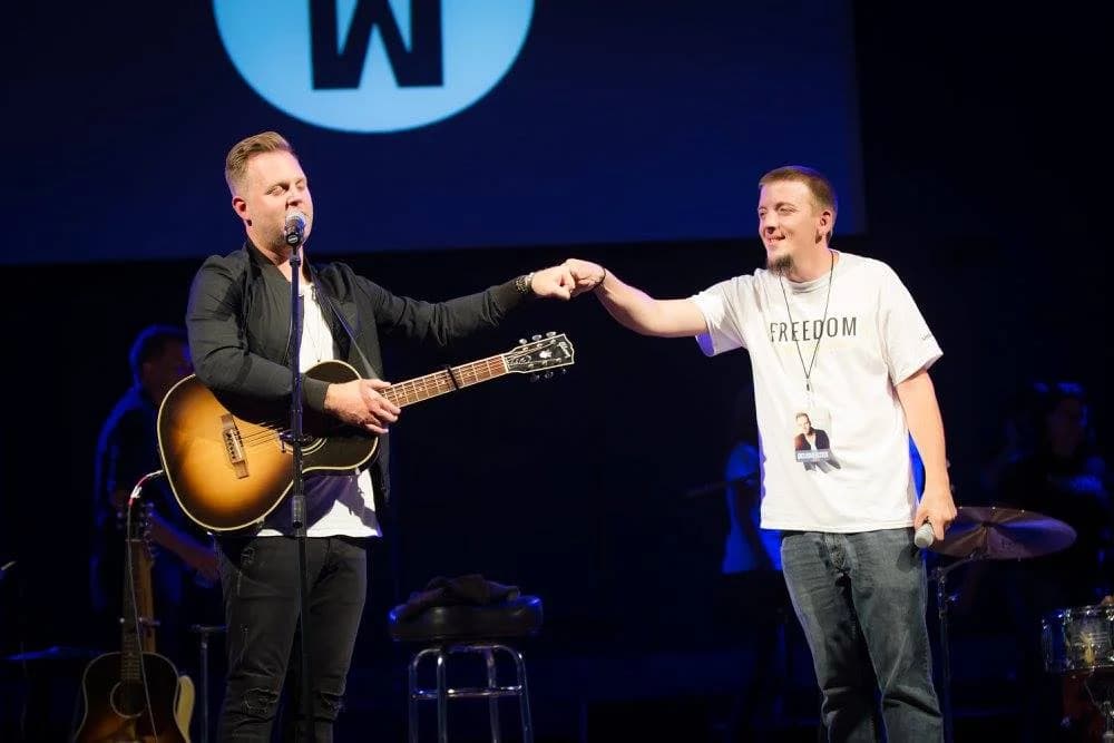 Justin and Matthew West fist-bumping on stage