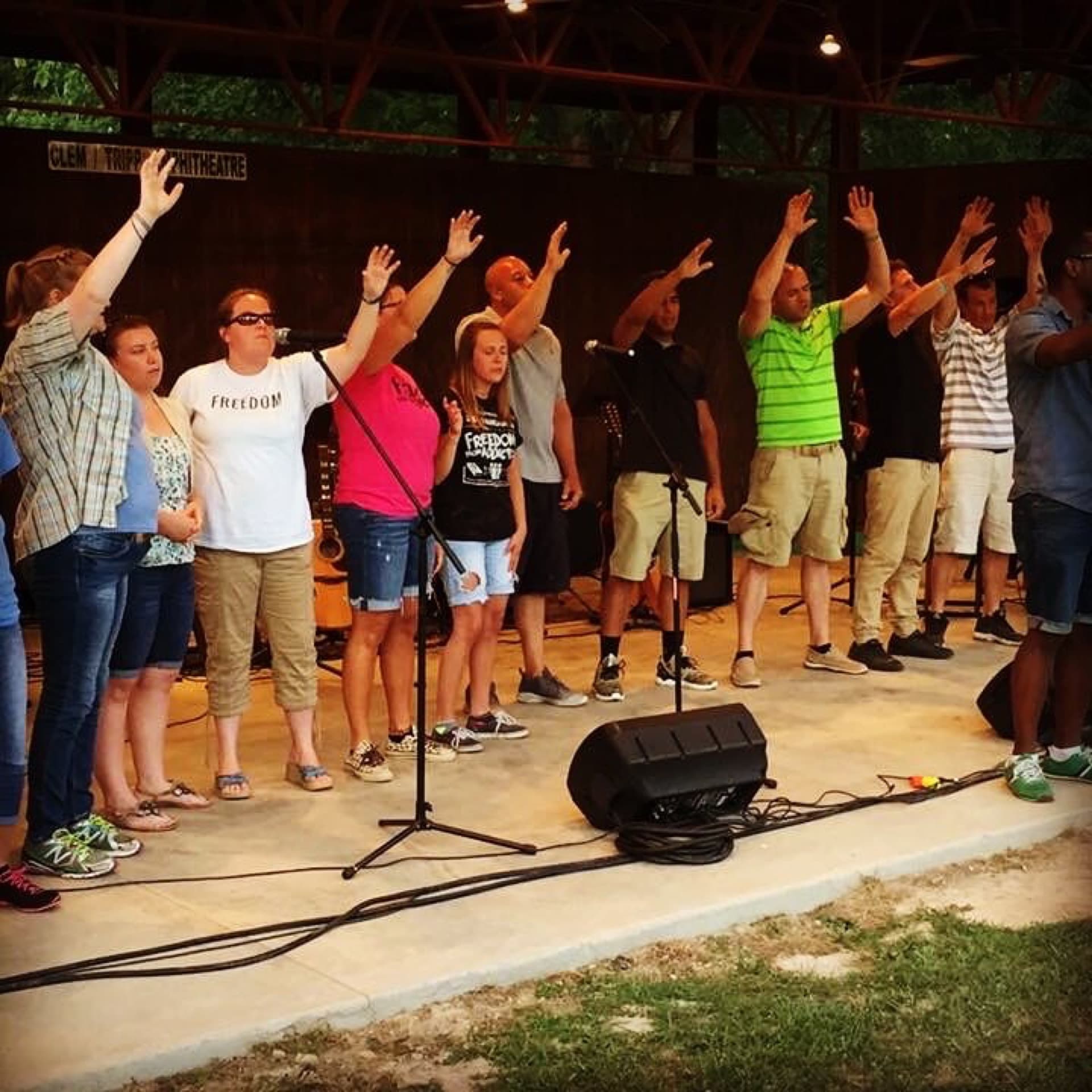 Teen Challenge men and women worshiping together at an outdoor amphitheater service