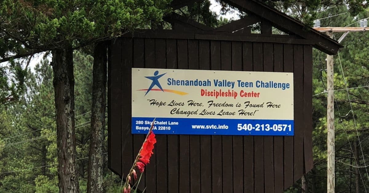 Shenandoah Valley Teen Challenge entrance sign surrounded by trees and flowers