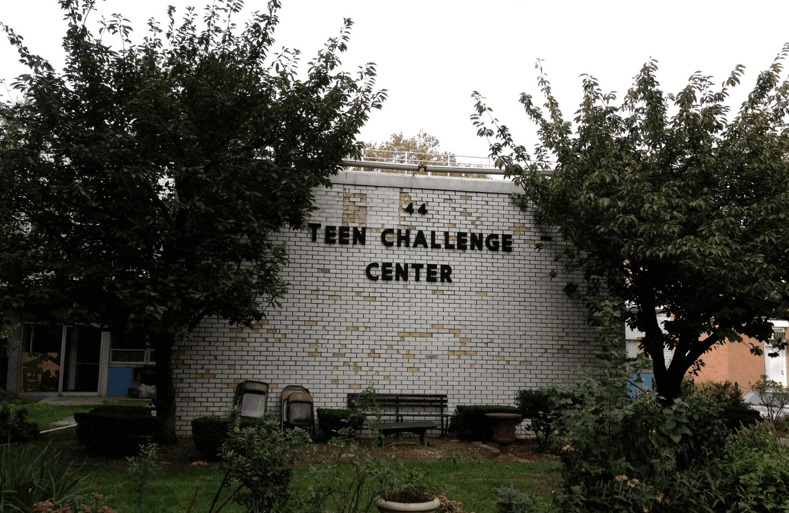 The original Brooklyn Teen Challenge Center building with trees and garden in front courtyard